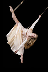 Young woman gymnast in white dress on rope