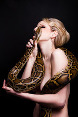 Obraz premium Kiss of attractive nude blond woman with python on black