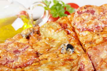 Italian cuisine. Pizza with salami, pickles and olives
