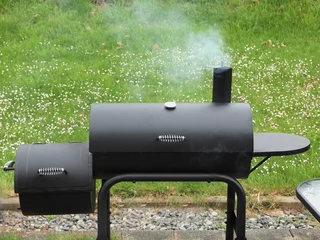 Papier Peint photo Grill / Barbecue Backyard barbequing on a charcoal smoker