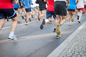 People running in city marathon on street