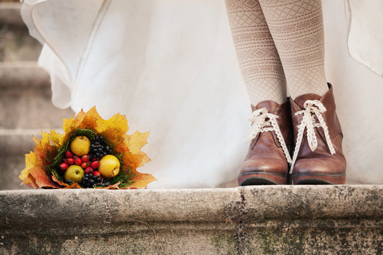 colorful autumn bouquet and two women legs with leather boots