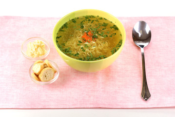 Tasty chicken stock with noodles on pink tablecloth