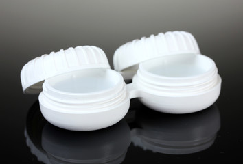 contact lenses in containers on grey background