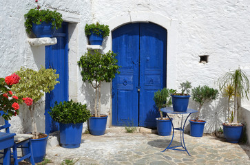 Typical greek courtyard with blue flower pots in Piskopiano.
