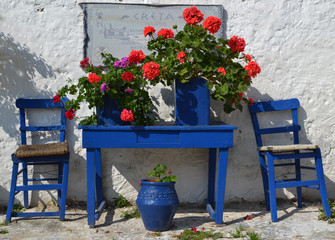 Typical greek courtyard with blue flower pots in Piskopiano.