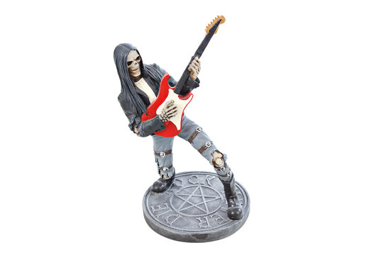 Figurine of skeleton rocker playing red electrical guitar