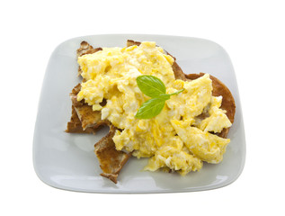 Scrambled Eggs on toasted bagles with  basil on white background