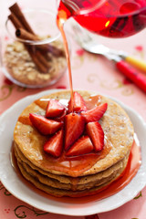 A stack of pancakes with fresh strawberries