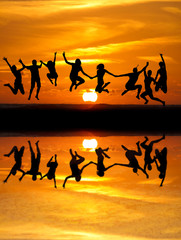 silhouette of kids jumping on beach in sunset - 41084162