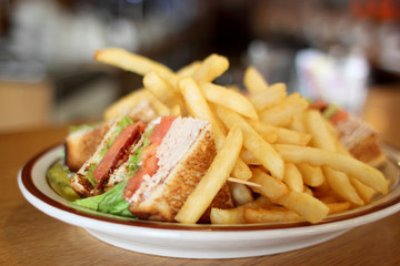 Delicious club sandwich with french fries at a diner.