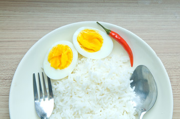 close up boiled egg and chilly on rice on wood background
