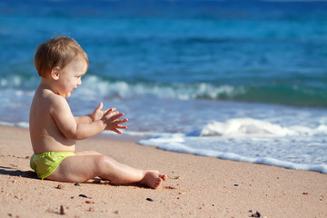 Happy toddler  on sand beach
