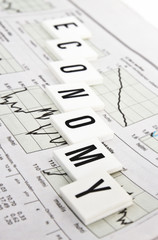 economy text written over stock market paper