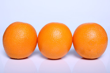 three fresh orange fruit in white