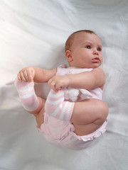 Младенец держится руками за ноги