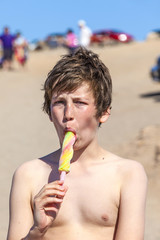 summer vacation: cute teen eating icecream on the beach
