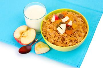 tasty cornflakes in bowl with dried fruits, glass of milk and