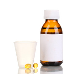 Medical bottle with jigger and tablets isolated on white