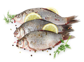 Fresh fishes with lemon, parsley and spice isolated on white