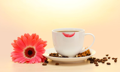 cup of coffee with lipstick mark and gerbera beans, cinnamon