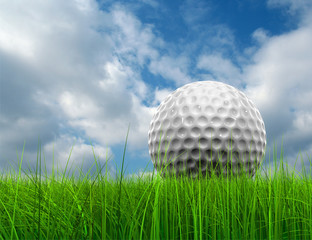 Conceptual golf ball in grass over a blue sky
