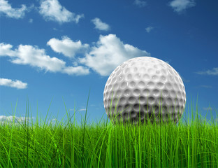 Conceptual golf ball in grass over a blue sky