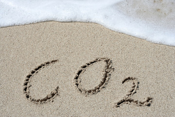 CO2 handwritten in sand on a beach