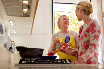 mom and daughter cooking in home kitchen