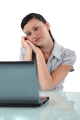 Happy brunette sitting at her desk