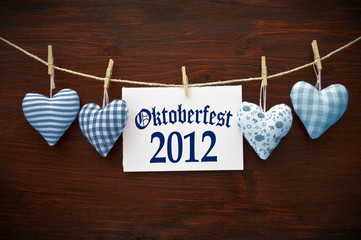 4 Stoffherzen in Blau auf Holzbrett mit Oktoberfest