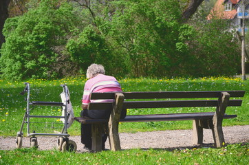 Seniorin in Isolation alleine auf Parkbank - obrazy, fototapety, plakaty