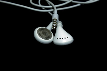 white earphones on a black background