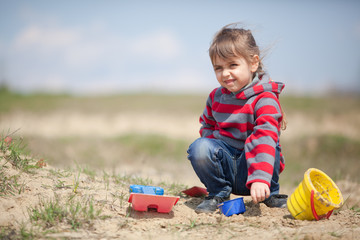 Little girl playing with sand