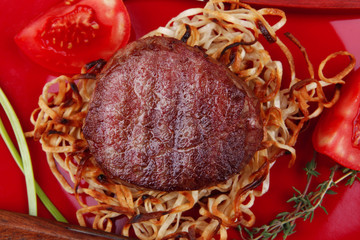 beef fillet pieces on noodles
