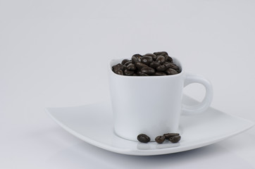 Espresso cup full of coffee beans