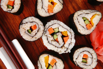 sushi rolls with wasabi and ginger on wooden plate