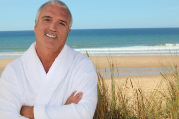 Fototapeta na wymiar Man in bathrobe on the beach