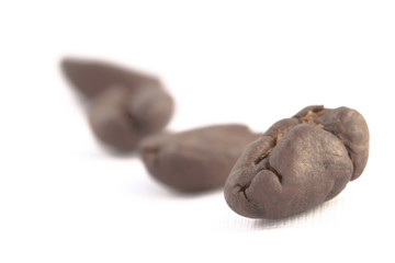 A few roasted coffee beans over the white background