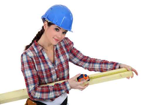 Woman measuring piece of wood