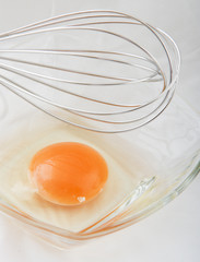 Hand Mixer with Eggs in a Glass Bowl