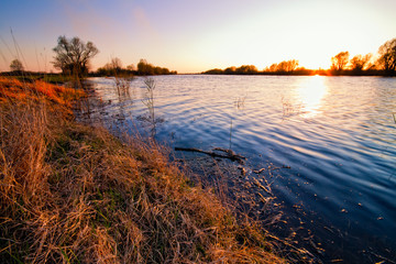 Fototapeta na wymiar spring landscape the river with the setting sun over the horizon