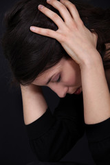 Woman holding head in pain