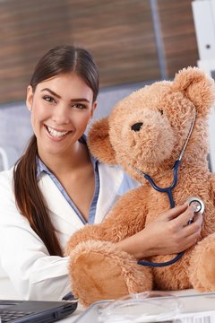 Laughing doctor with teddy bear