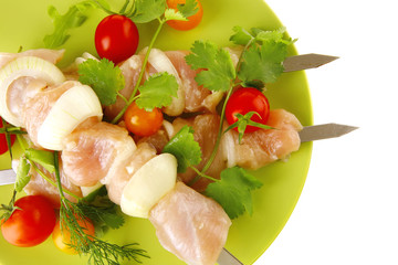 raw chicken kebabs on dark plate