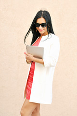 Female in sunglasses using tablet pc outdoors