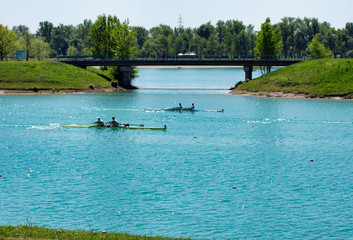 Race rowers on lake Jarun, bridge in back, Croatia