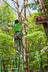Fototapeta premium Мальчик преодолевает препятствие, идя по веревке