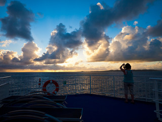 Fototapeta premium woman taking picture of sunrise