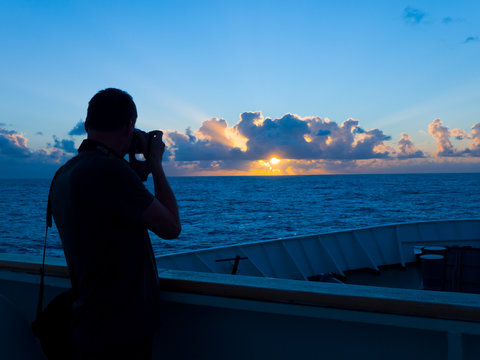 man taking photo of sunrise